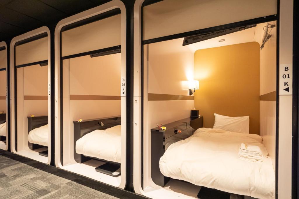 A corridor of white sleeping compartments with roller screens partly lowered.